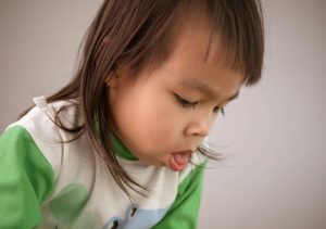 A child gagging on food, demonstrating signs of distress