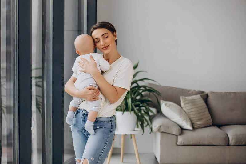 Soothe an infant by holding upright and patting back gently