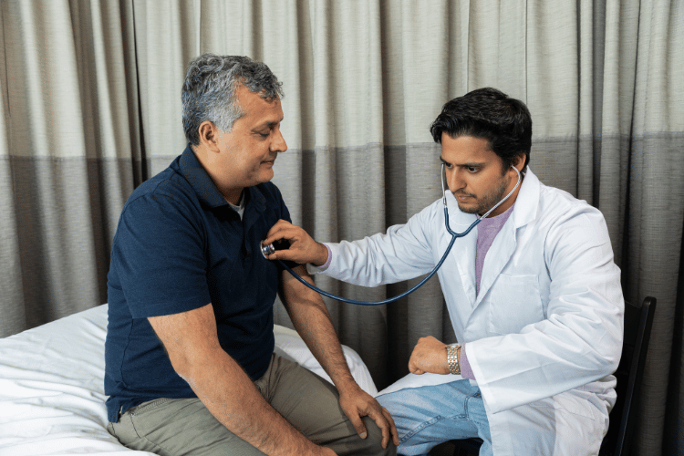 Doctor checking elderly man's heart rate